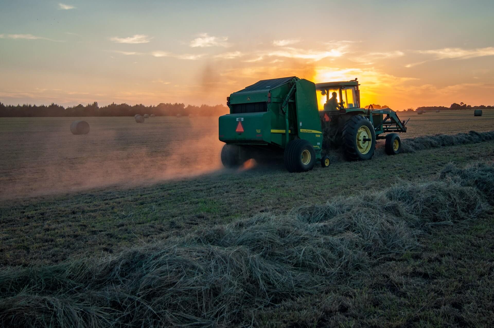 Tractor in front of sunset in field