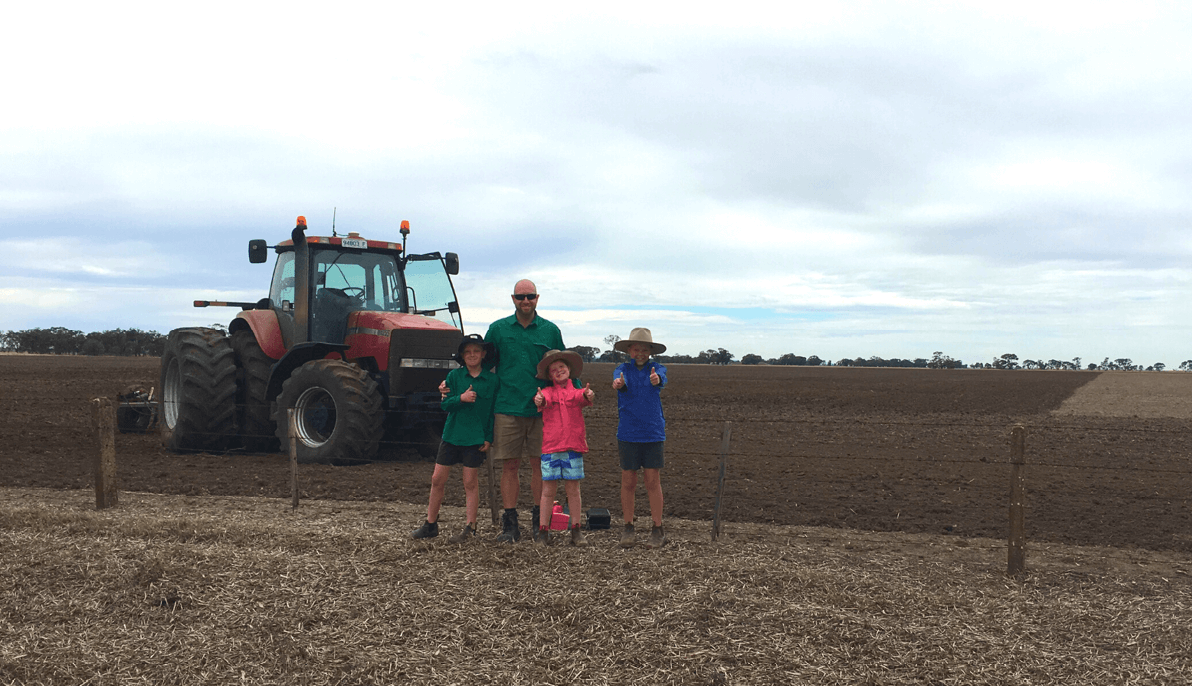 Children posing in front of tractor